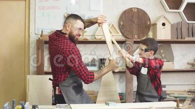 父亲和儿子在木匠车间玩木制<strong>DIY</strong>剑的骑士